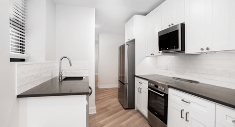 a kitchen with white cabinets and stainless steel appliances